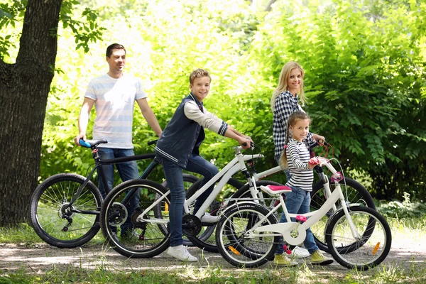 Happy family with bikes in park — Stock Photo, Image