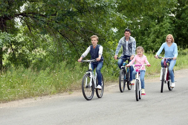 Família feliz andar de bicicleta na estrada — Fotografia de Stock