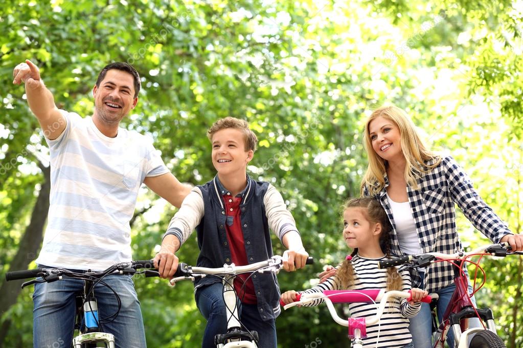 Happy family with bikes in park