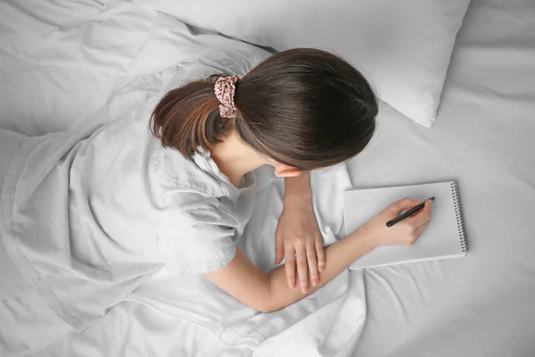 Woman with notebook writing — Stock Photo, Image