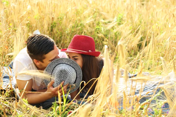 Casal jovem deitado em um campo — Fotografia de Stock