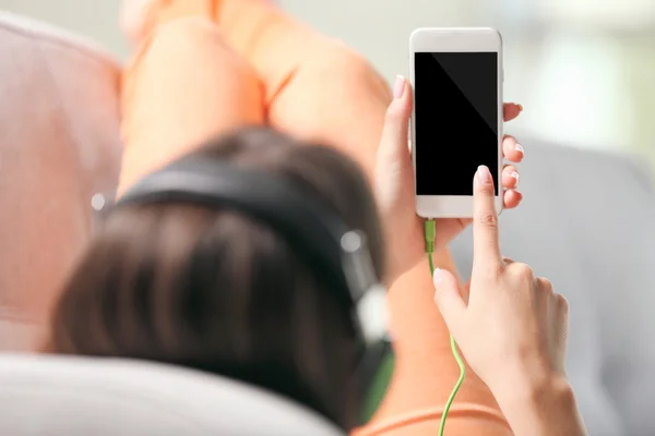 Mujer escuchando música en un smartphone — Foto de Stock