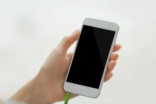 Mano femenina sosteniendo teléfono inteligente — Foto de Stock