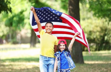 Erkek ve kız Amerikan bayrağı tutarak 