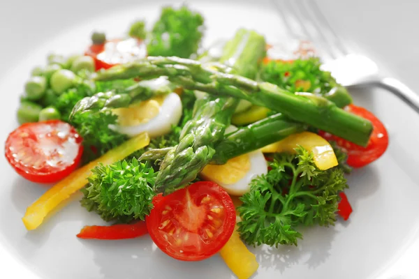 Спаржа с овощами на тарелке — стоковое фото