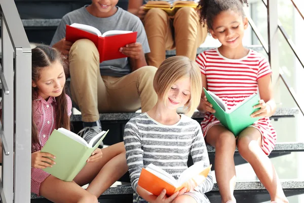 Lindos niños leyendo libros en las escaleras — Foto de Stock