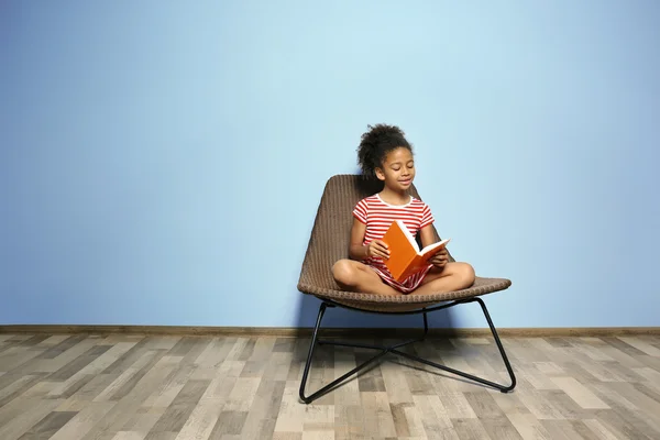 Bonito Menina Leitura Livro Azul Parede Fundo — Fotografia de Stock