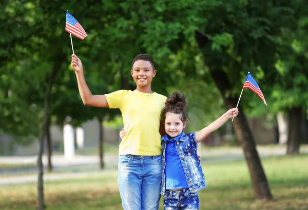 Niño y niña con banderas americanas Fotos De Stock Sin Royalties Gratis