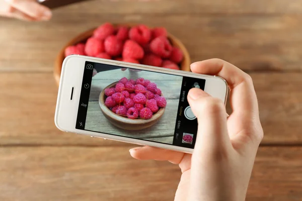 Woman taking photo of raspberry — Stock Photo, Image