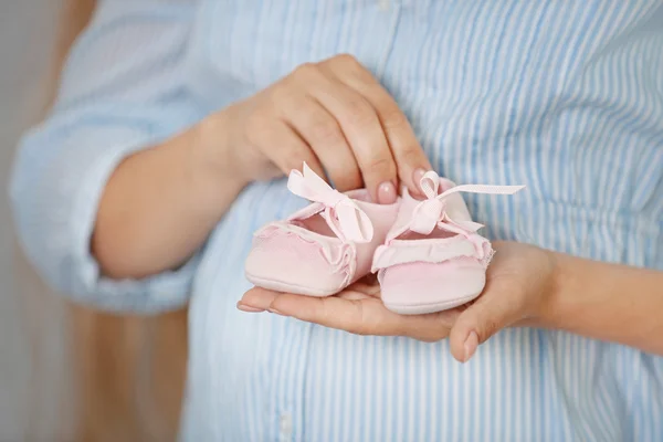 Wanita hamil dengan bootees bayi — Stok Foto