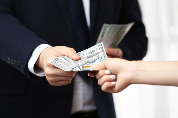 Man in suit taking bribe from woman hand — Stock Photo, Image