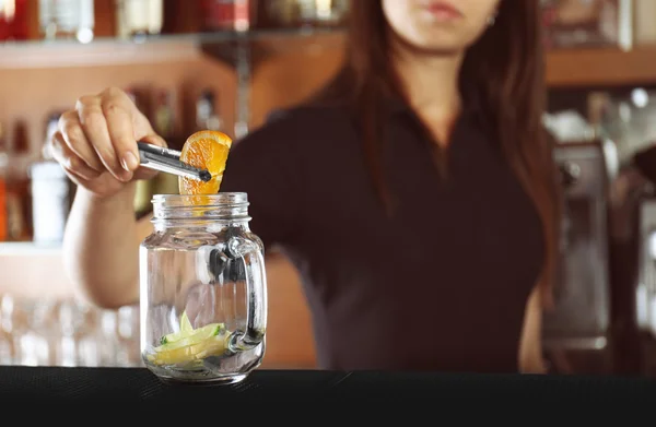 Manos de mujer poniendo frutas en frasco de vidrio — Foto de Stock