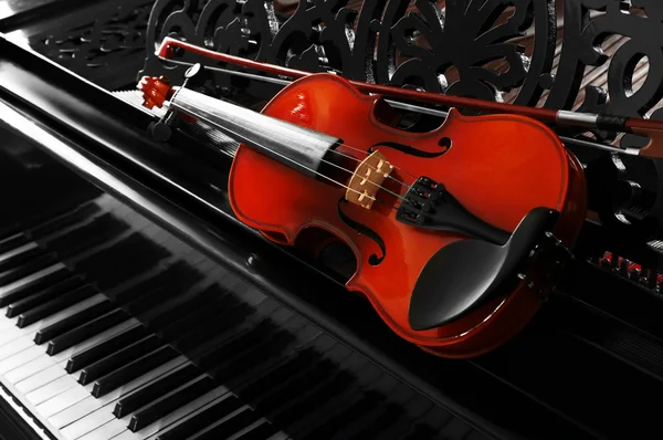 Violin lying on piano, close up — Stock Photo, Image