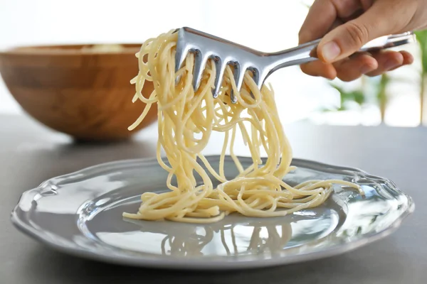 Female hand putting spaghetti — Stock Photo, Image