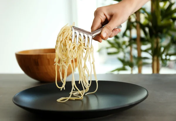 Женская рука кладет спагетти — стоковое фото