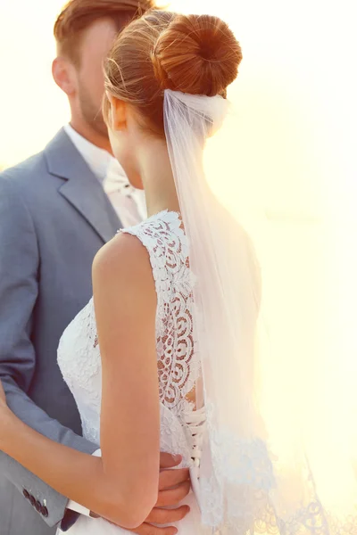 Brudgummen och bruden kramas, utomhus — Stockfoto