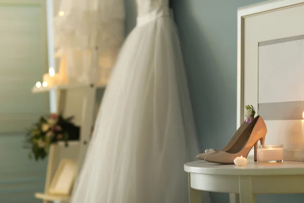 Обувь на столе и свадебное платье — стоковое фото