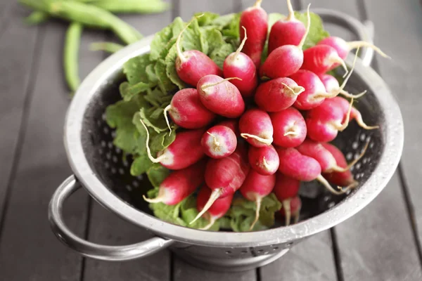 Heap of radishes in colander — Stock Photo, Image
