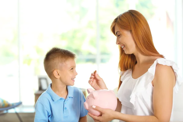 Conceito Poupança Mãe Menino Colocando Moedas Banco Porquinho Fotografia De Stock