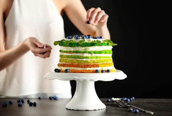Женщина украшает вкусный торт — стоковое фото