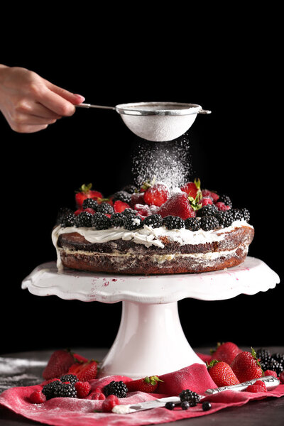 Женщина украшает сладкий фруктовый пирог
 