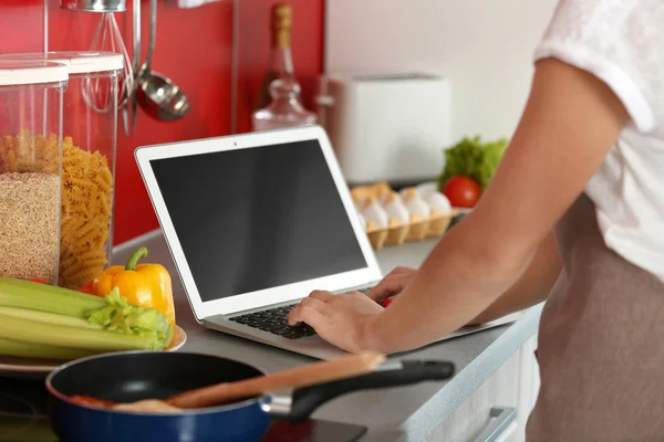 Девушка с ноутбуком на кухне — стоковое фото