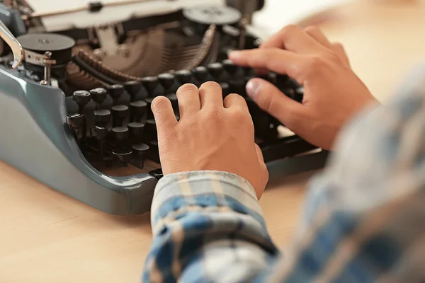 Hombre trabajando en una máquina de escribir retro — Foto de Stock
