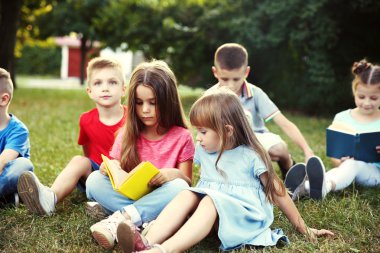 Parkta grup mutlu çocuk okuma kitapları
