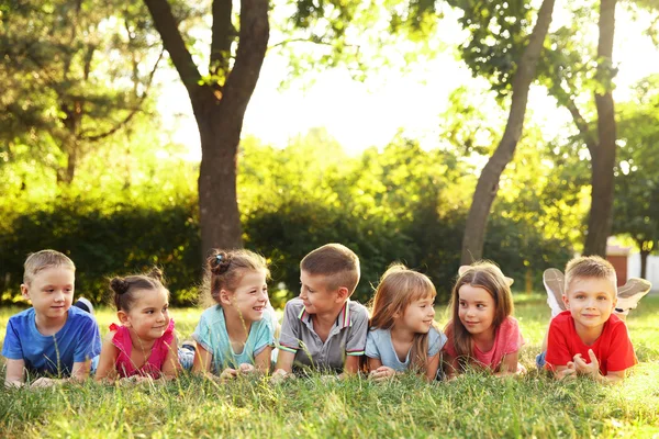 Enfants Heureux Couchés Sur Herbe Dans Parc Images De Stock Libres De Droits