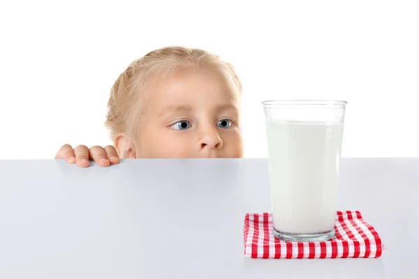 Funny little girl hiding behind table — Stock Photo, Image