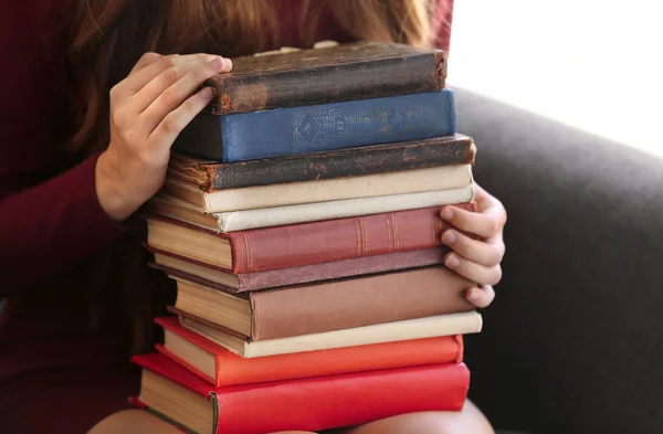 Mujer sosteniendo pila de libros — Foto de Stock