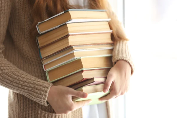 Mujer sosteniendo pila de libros antiguos — Foto de Stock