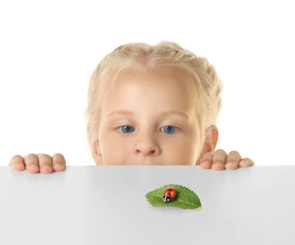 Funny little girl hiding behind table — Stock Photo, Image