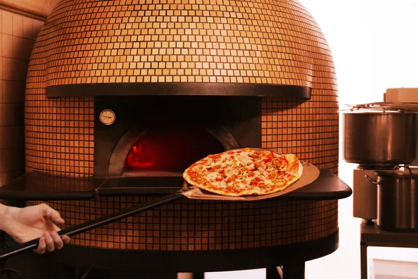 Umieszczenie pizzy w piecu opalanym drewnem — Zdjęcie stockowe