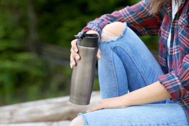 Günlükleri yığını üzerinde oturan kadın