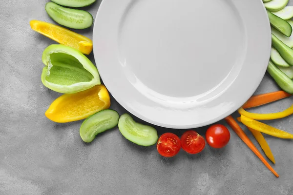 Empty plate with sliced vegetables — Stock Photo, Image