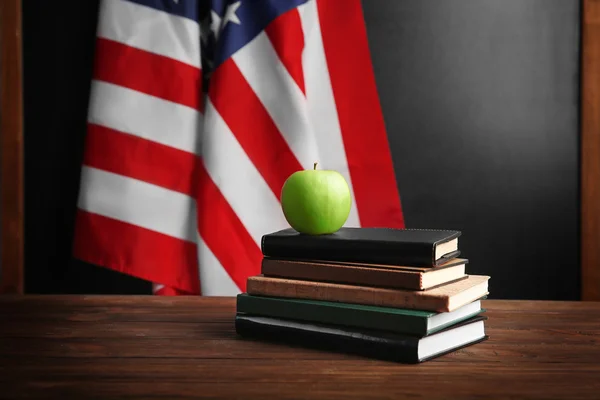 Books with apple on American flag — Stock Photo, Image