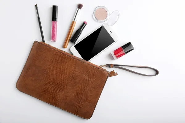 Bolsa de maquillaje con productos de belleza y teléfono sobre fondo blanco —  Fotos de Stock