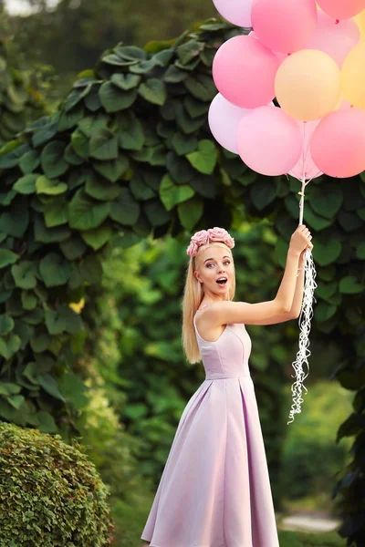 Όμορφη νεαρή γυναίκα κρατώντας αερόστατα αέρα — Φωτογραφία Αρχείου