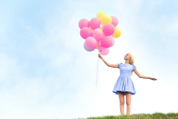 Piękna młoda kobieta trzyma balony powietrzne — Zdjęcie stockowe