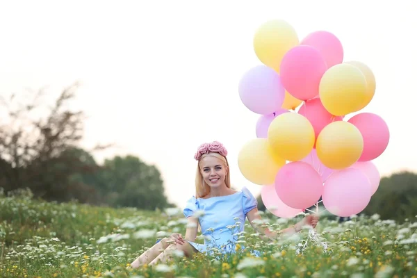 Piękna młoda kobieta trzyma balony powietrzne — Zdjęcie stockowe