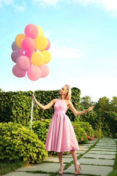 Beautiful young woman holding air balloons — Stock Photo, Image