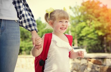 Anne kızını okula götürüyor.