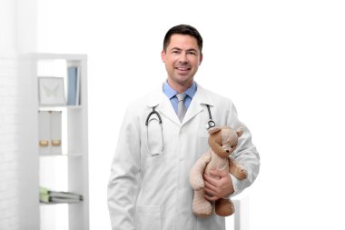 Çocuk doktoru doktor ofisinde oyuncak ayı ile