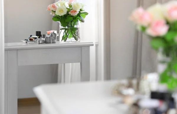 Bukett av rosor på ljus toalettbord återspeglar i spegel — Stockfoto