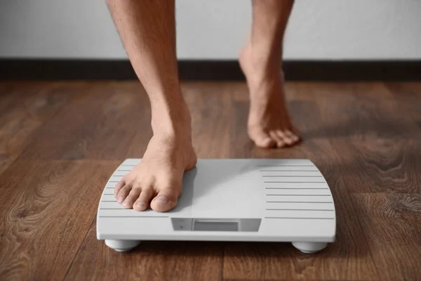 Man standing on weight scale — Stock Photo, Image