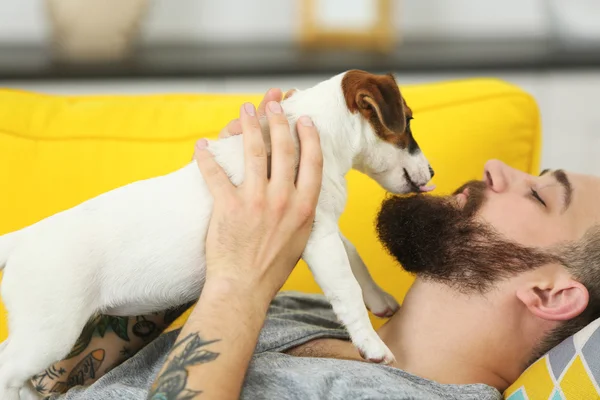 Hombre guapo con lindo perro en casa — Foto de Stock