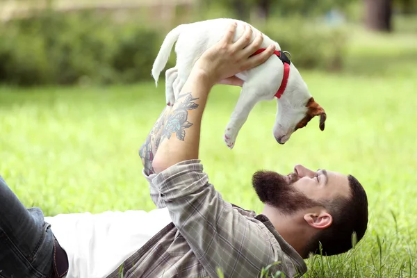 Man with cute dog in spring park — Stock Photo, Image