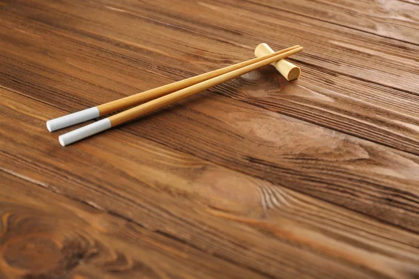 Light chopsticks on wooden background — Stock Photo, Image