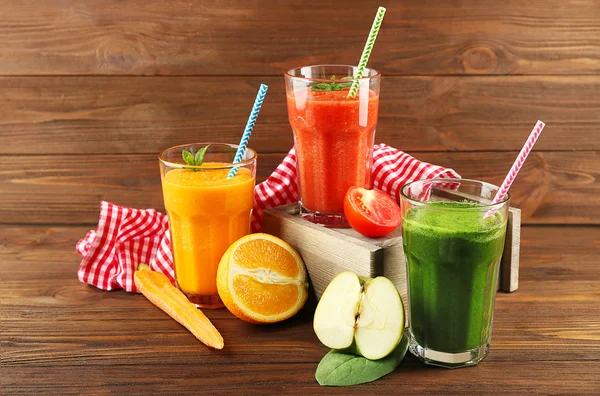 Sabrosas bebidas de batido con verduras y frutas en la mesa —  Fotos de Stock